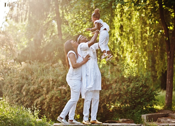 african american rich family having fun on sunset. father throws